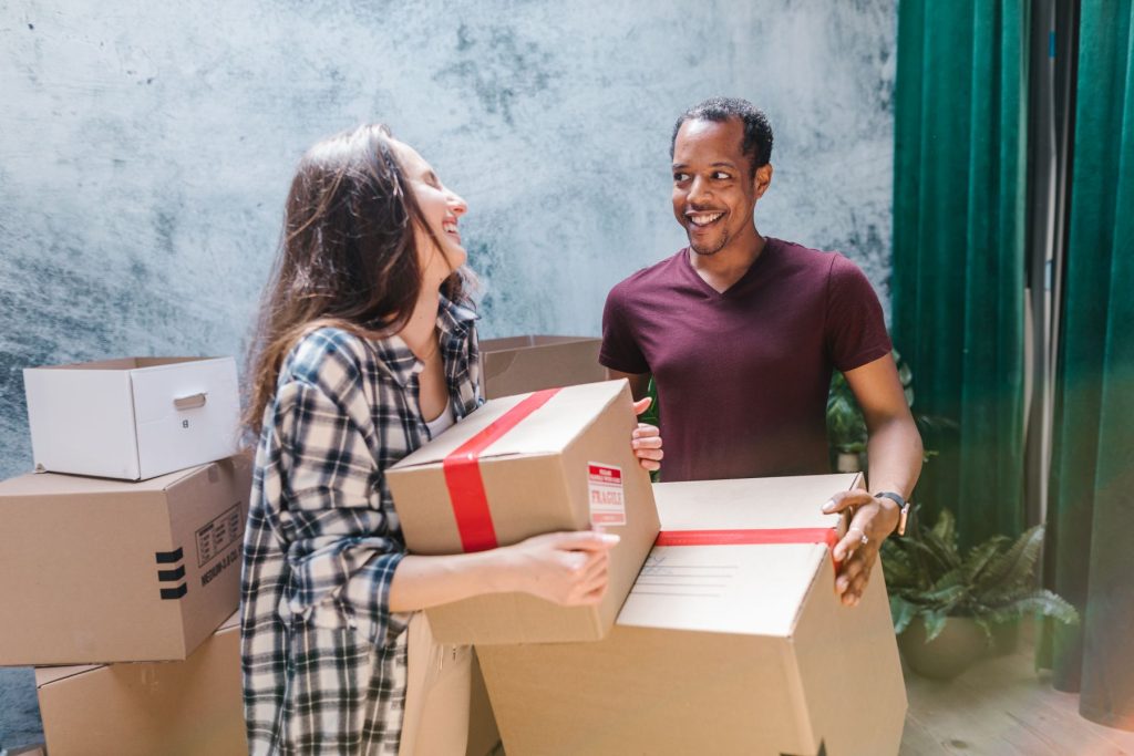 Movers holding labeled moving boxes