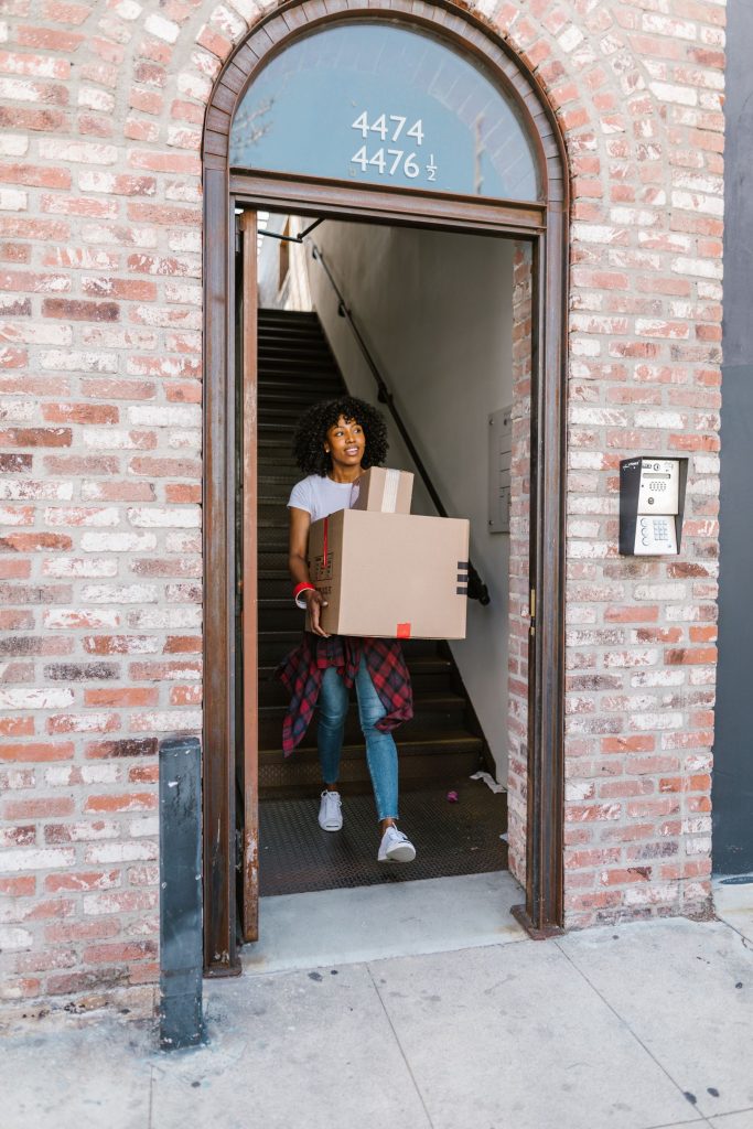 Mover carrying a box out of an apartment building