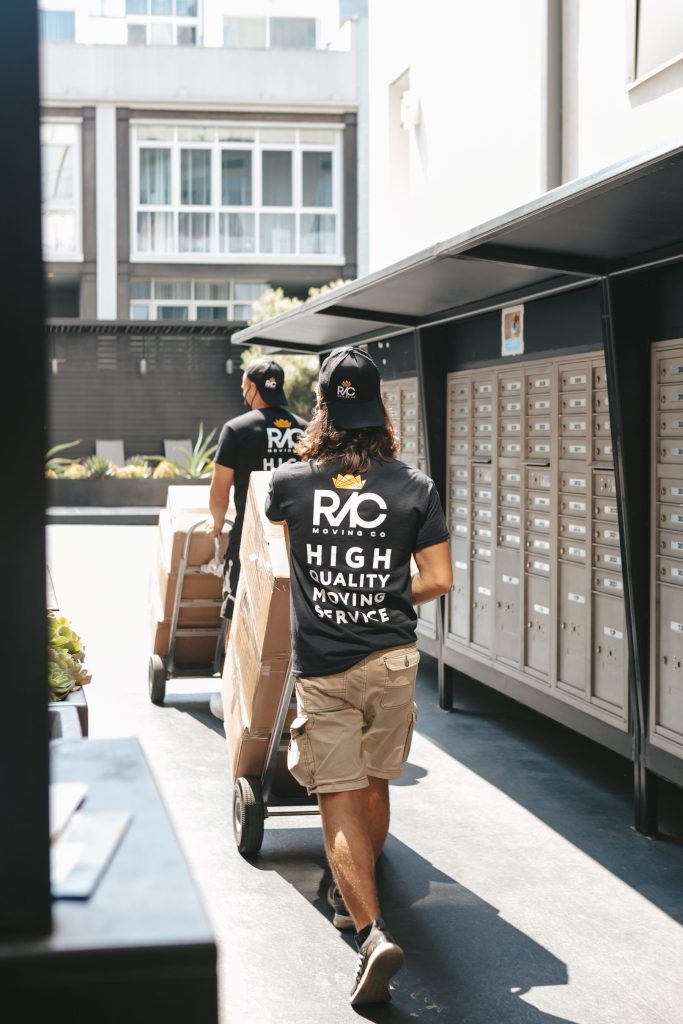 Movers carrying boxes on a city street