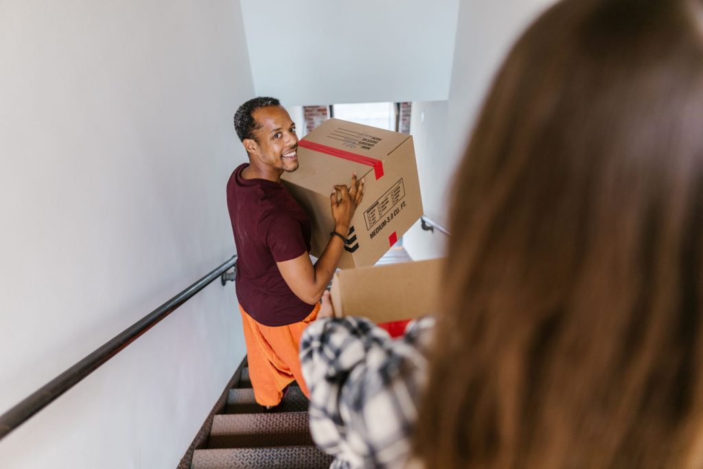 Mover carrying a box up a staircase