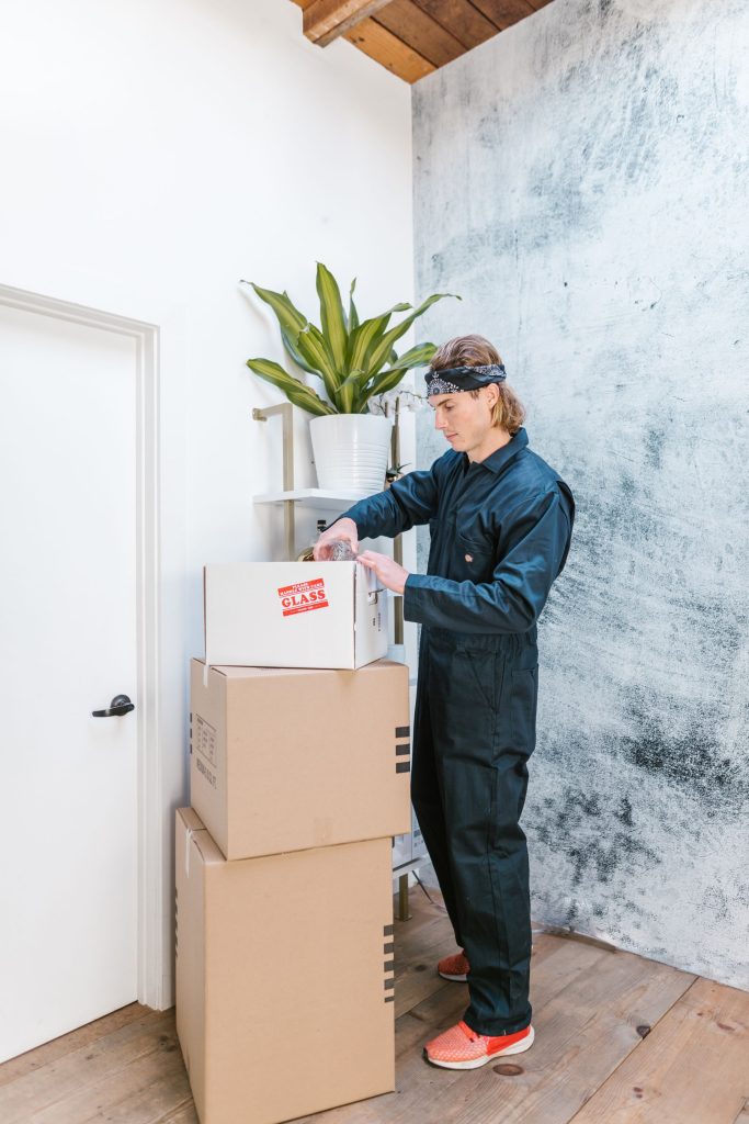 Mover stacking boxes beside a potted plant